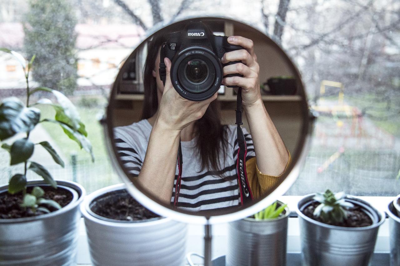 Lány fényképezi magát egy tükörön keresztül
