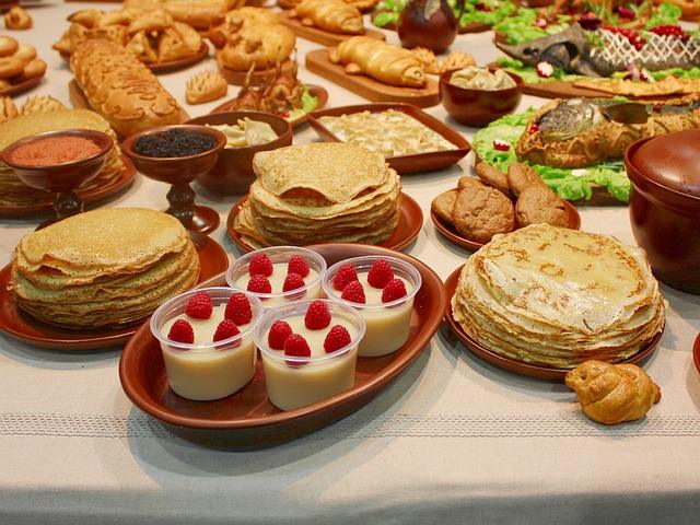 Rich table with pancakes and desserts