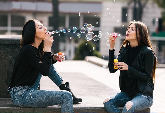 Girls blow soap bubbles